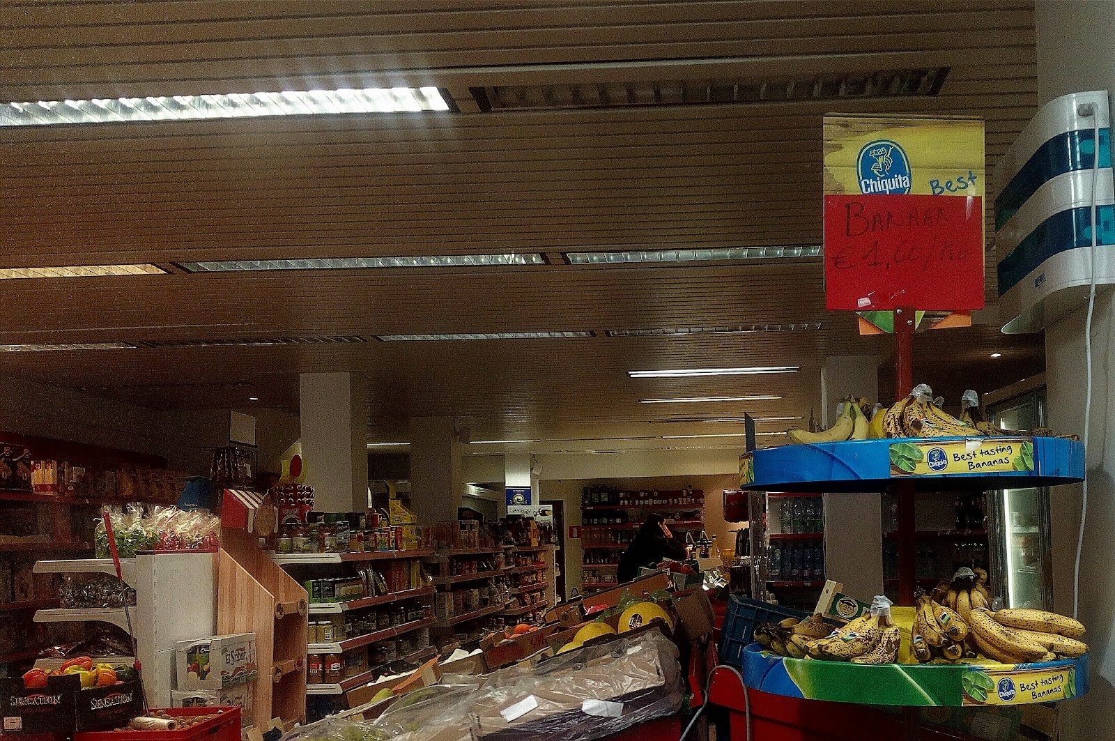 Rekken met producten en verse bananen in de winkel